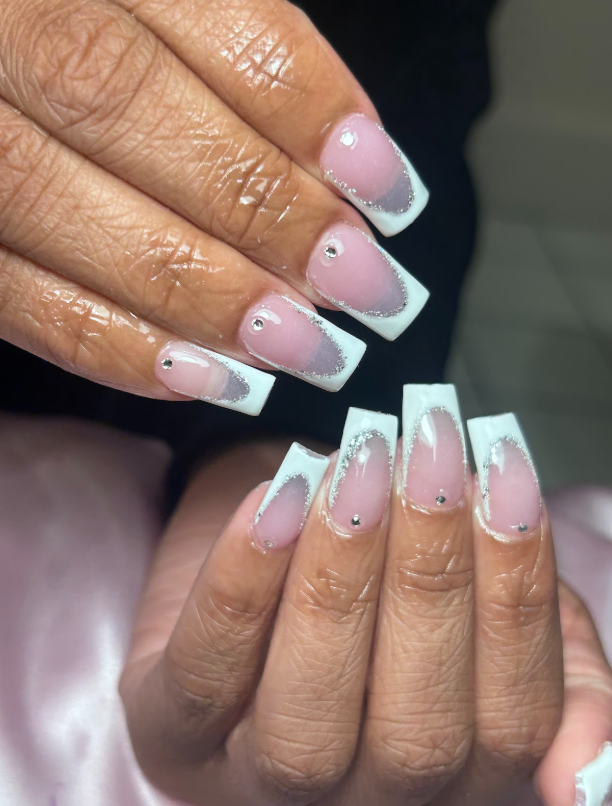 A close up of a woman 's nails with a French manicure.