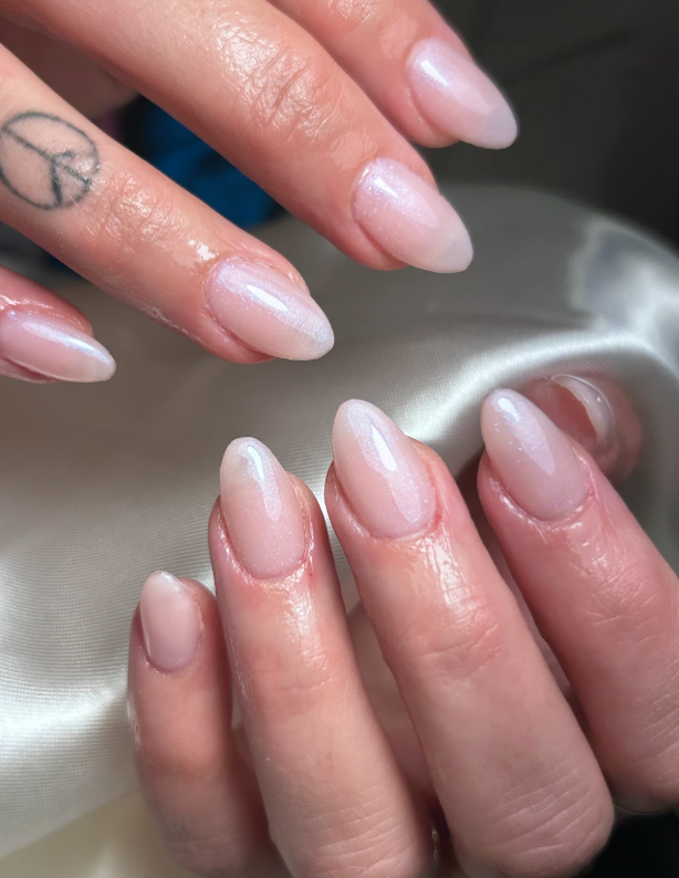 A close up of a woman 's nails with a peace sign tattoo on her finger.