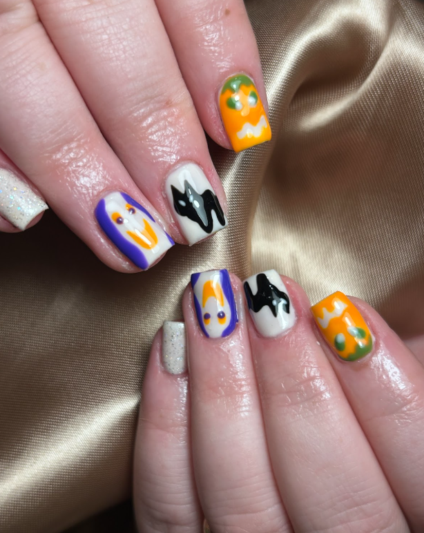 A close up of a woman 's nails with Halloween designs on them.