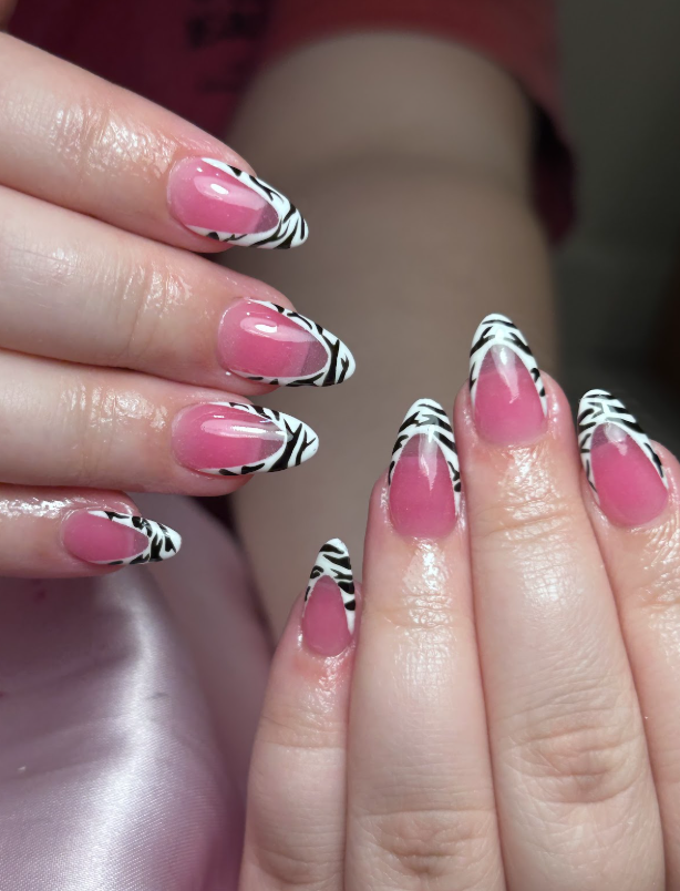A close up of a woman 's nails with a zebra print design.