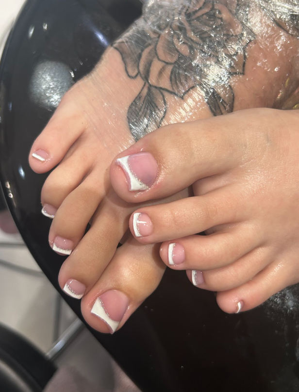A close up of a woman 's feet with manicure.