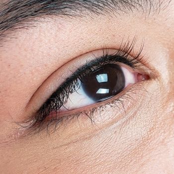 A close up of a woman 's eye with long eyelashes.