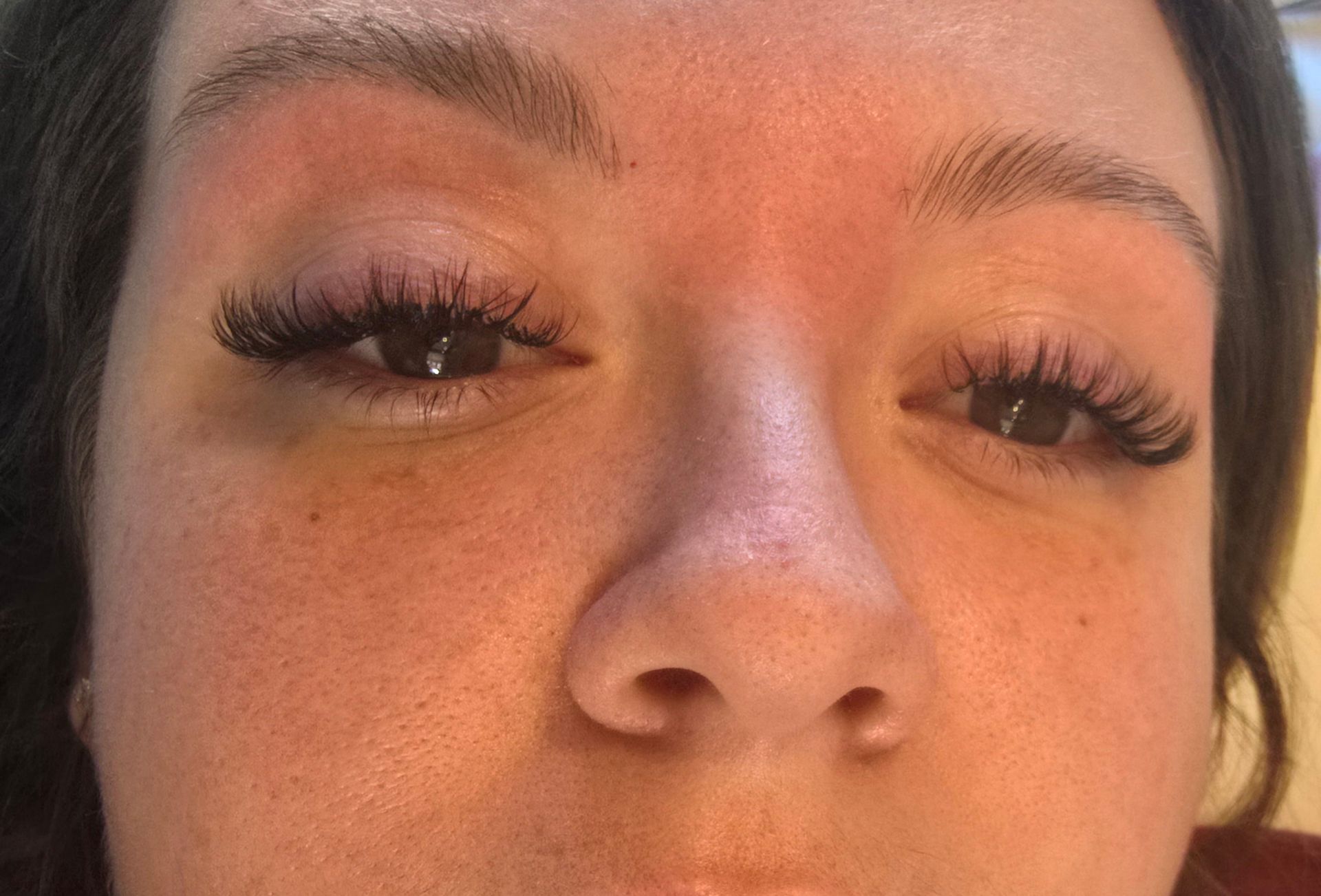 A close up of a woman 's face with long eyelashes.