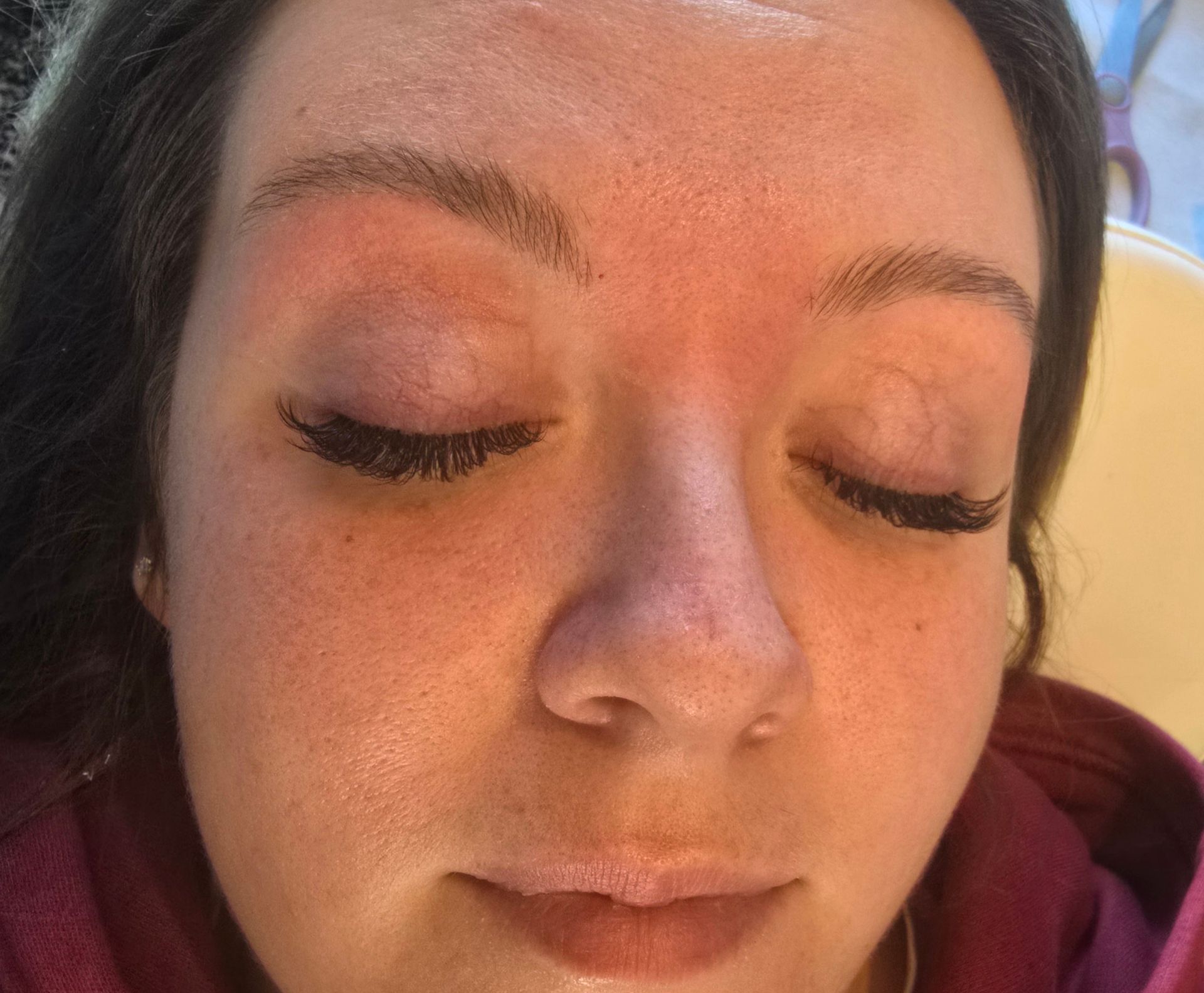 A close up of a woman 's face with her eyes closed.