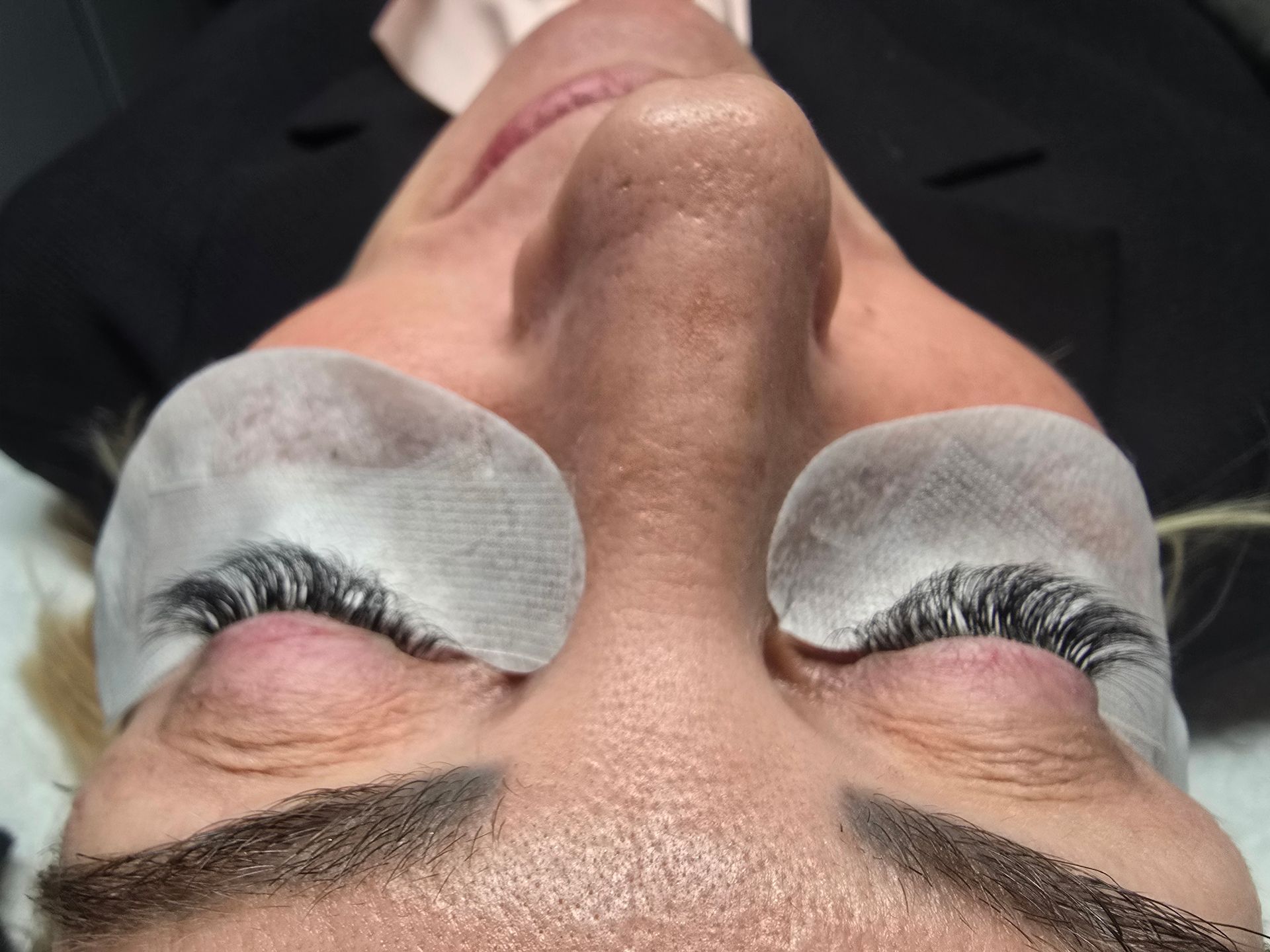A close up of a woman 's face with false eyelashes on her eyes.