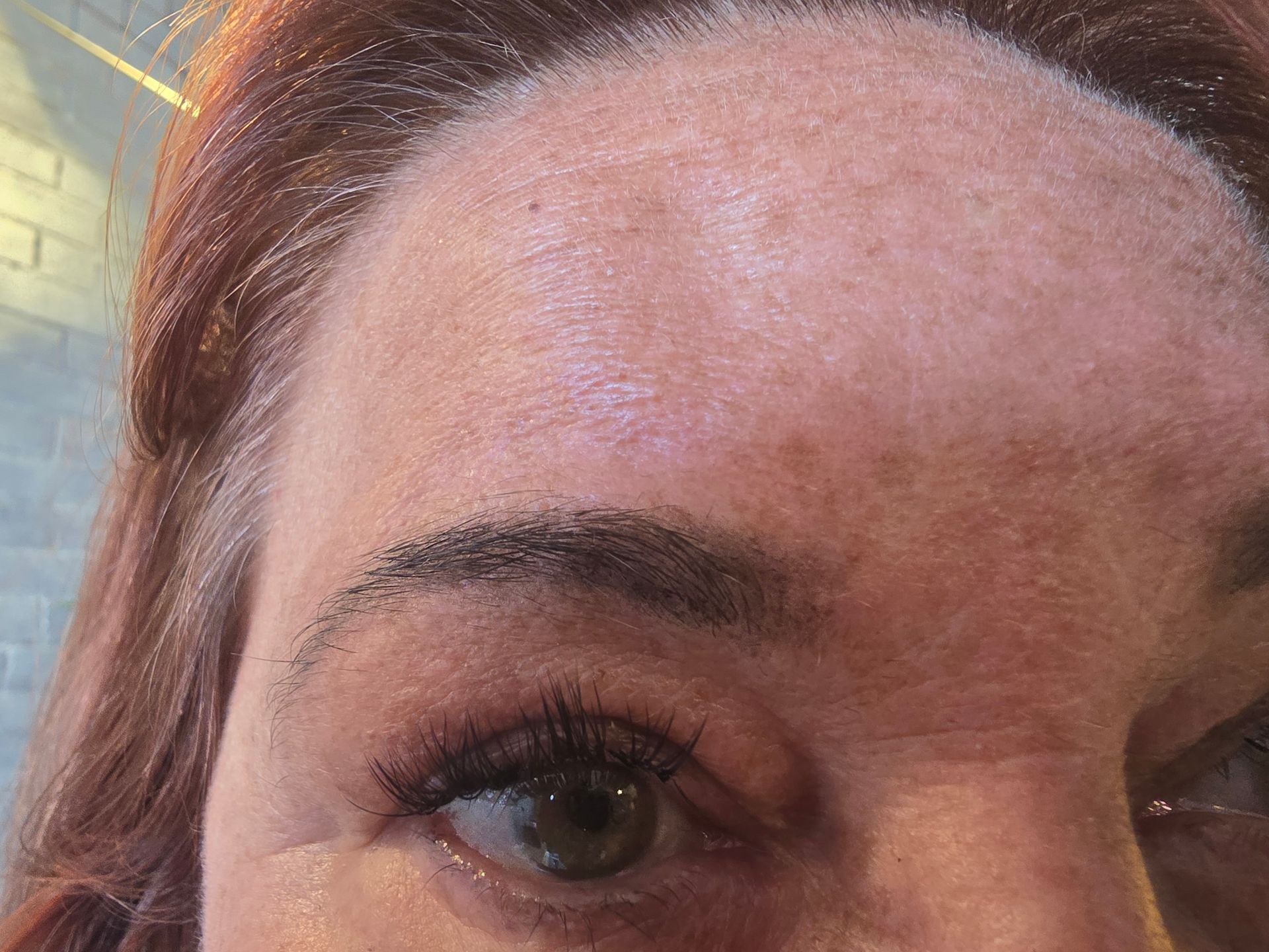 A close up of a woman 's forehead and eye.