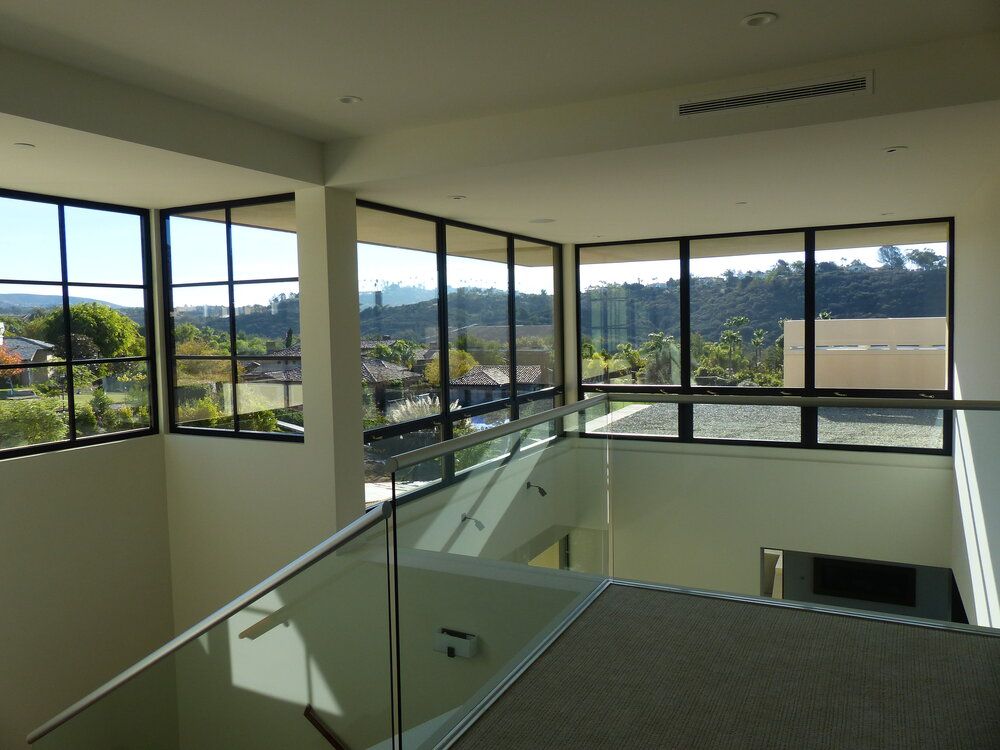 A staircase with a glass railing and lots of windows