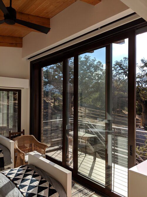 A bedroom with a lot of windows and a ceiling fan