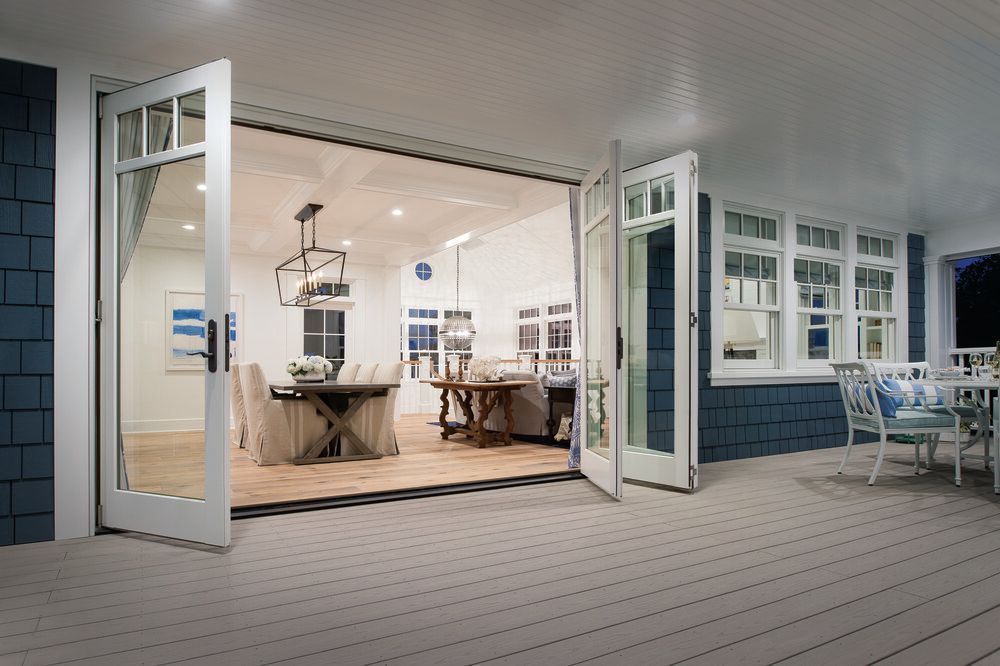 A large deck with sliding glass doors leading to a living room and dining room.