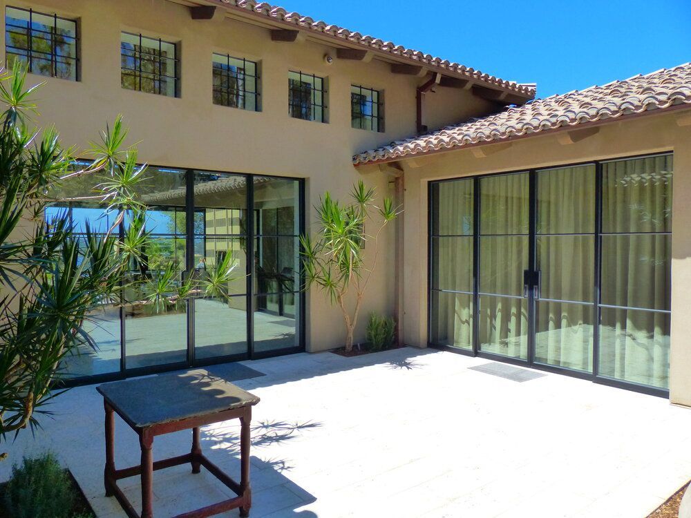 A large house with a lot of windows and sliding glass doors