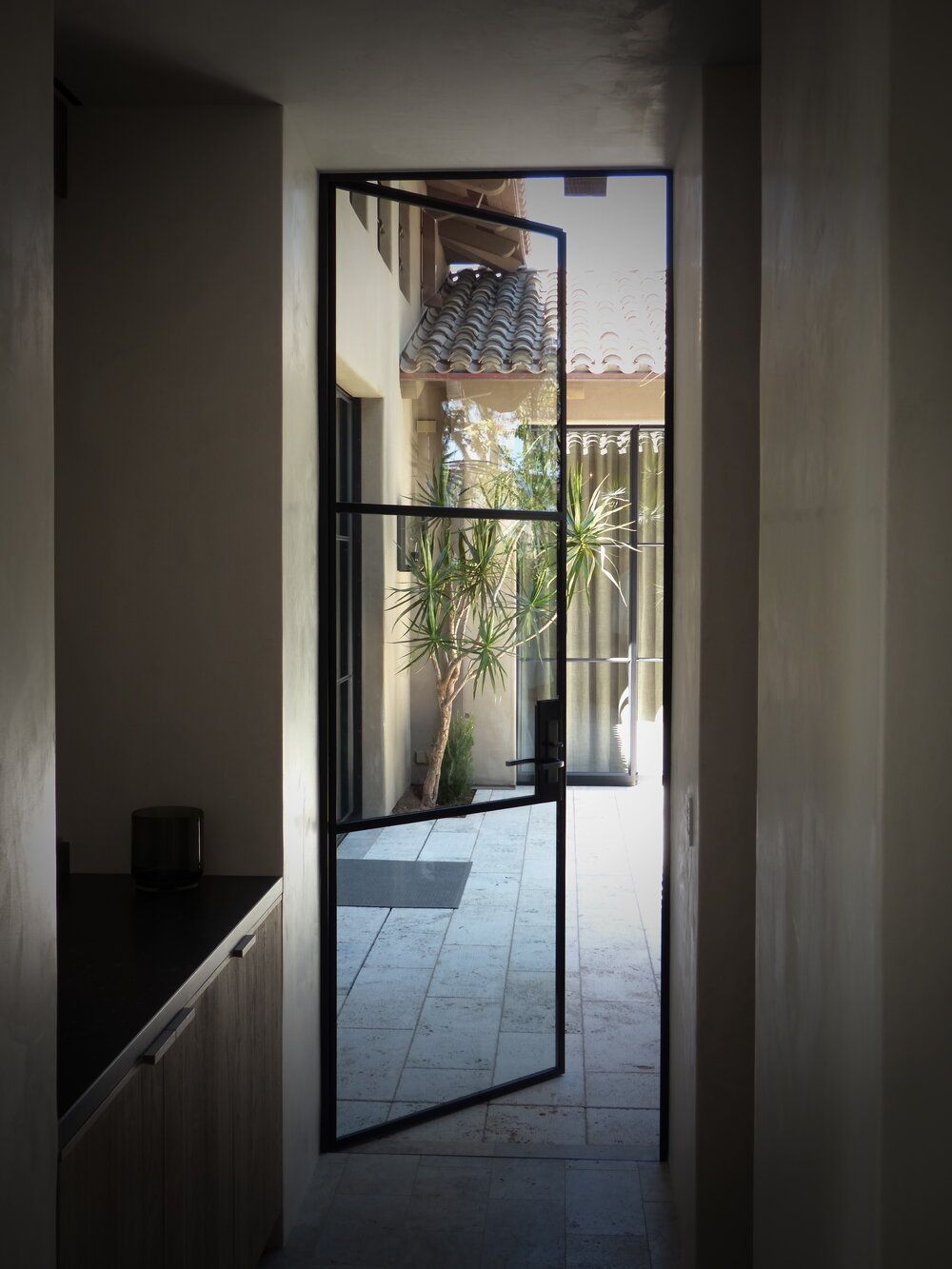 A hallway with a glass door leading to a patio