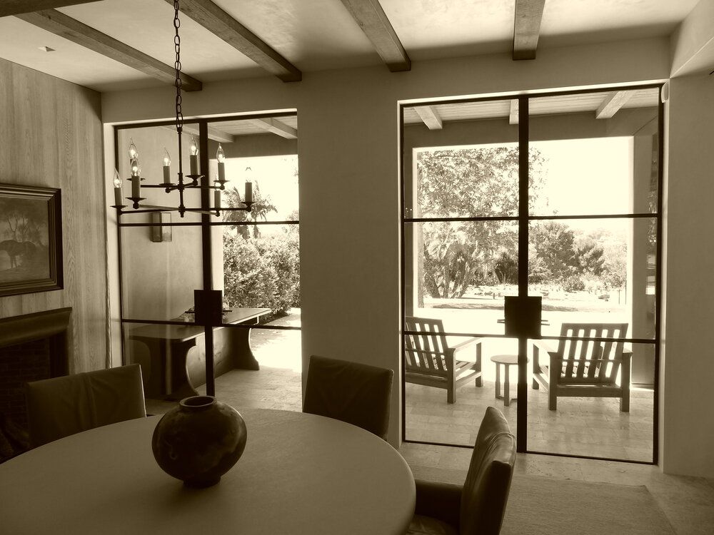 A black and white photo of a dining room with a table and chairs