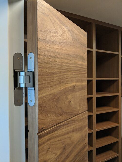 A wooden door is open to a closet with shelves.