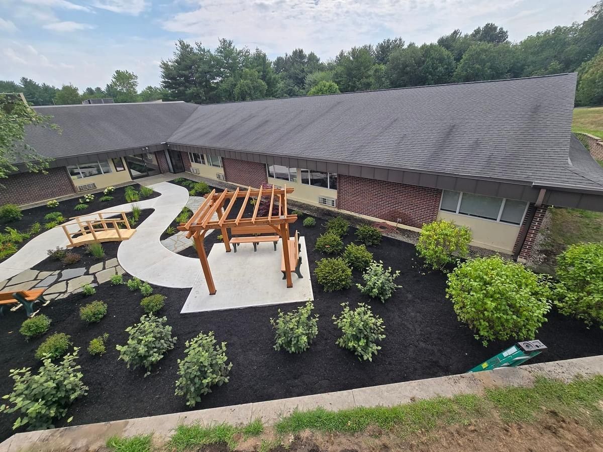 An aerial view of a house with a pergola in front of it.