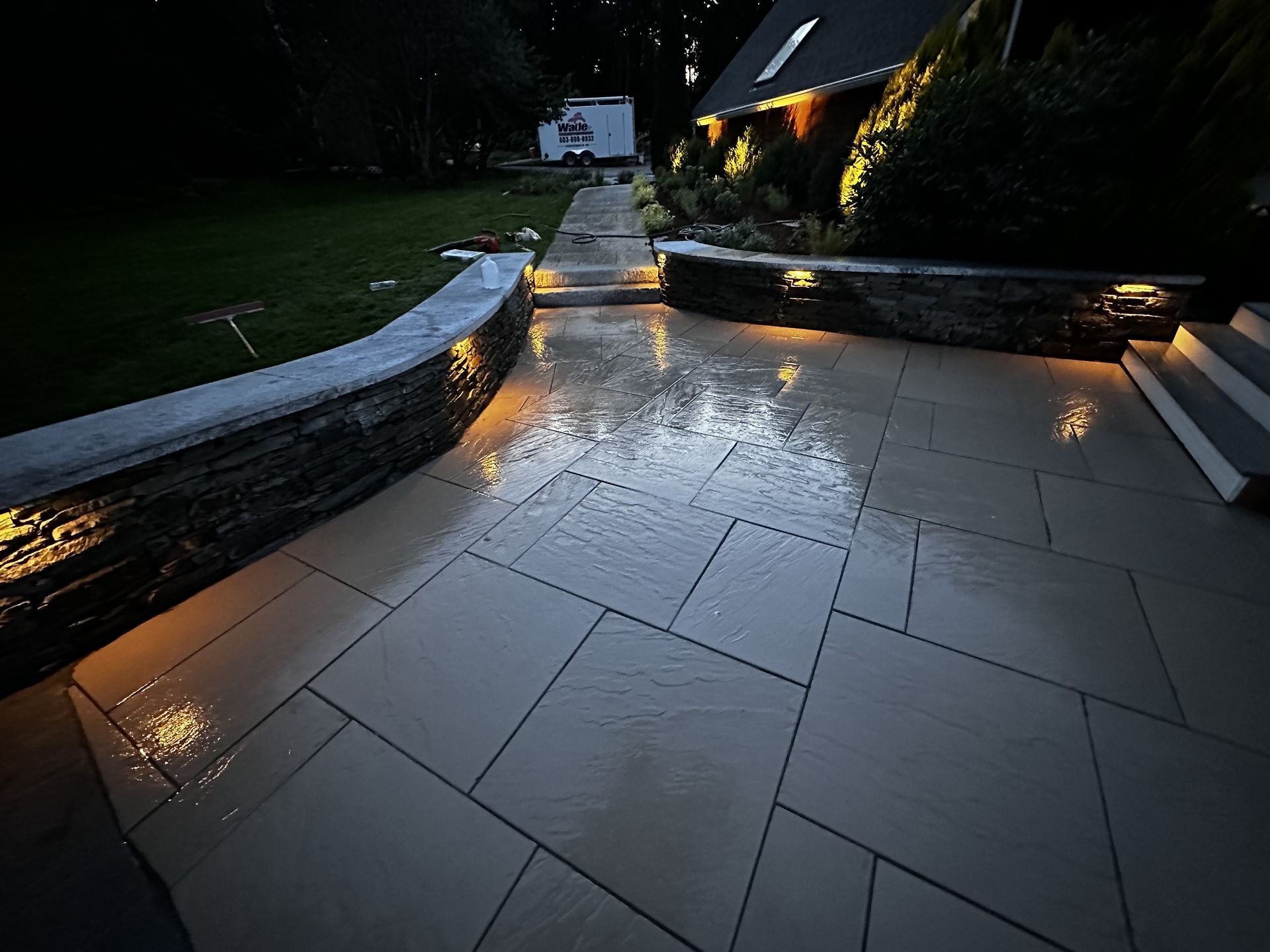A patio with lights on it and a house in the background