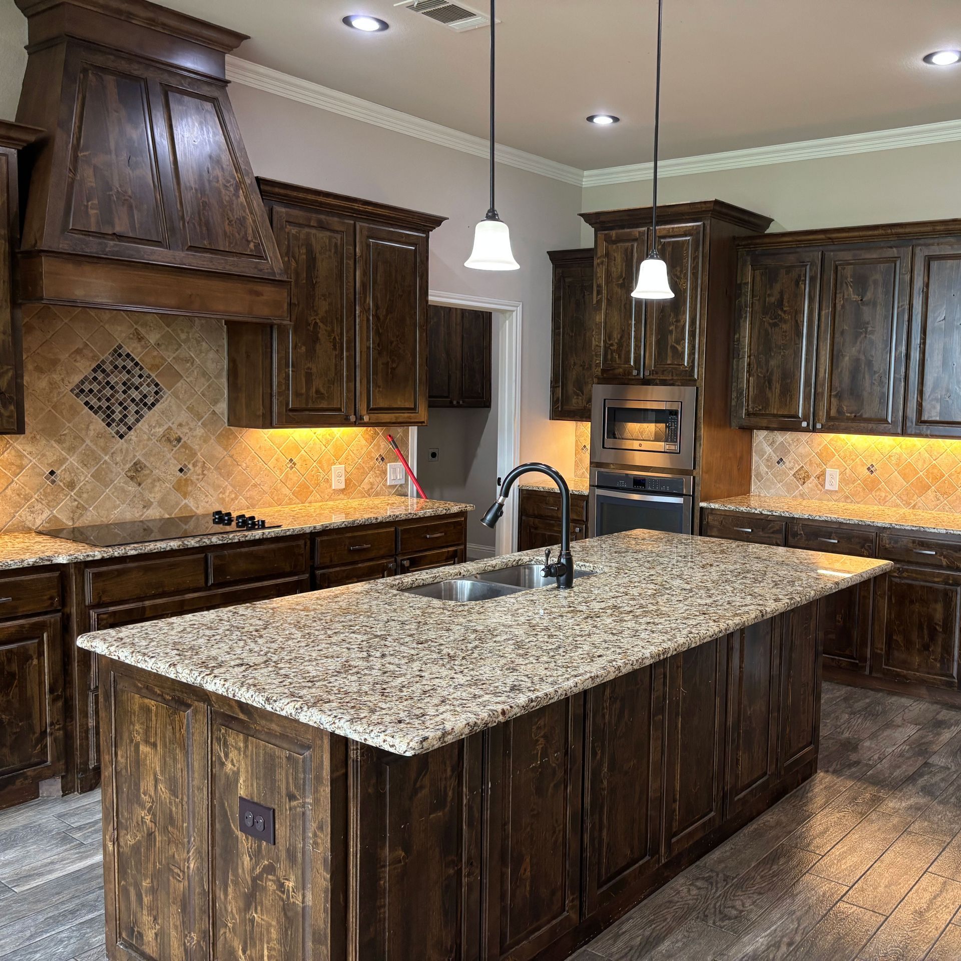 A kitchen with granite counter tops and wooden cabinets