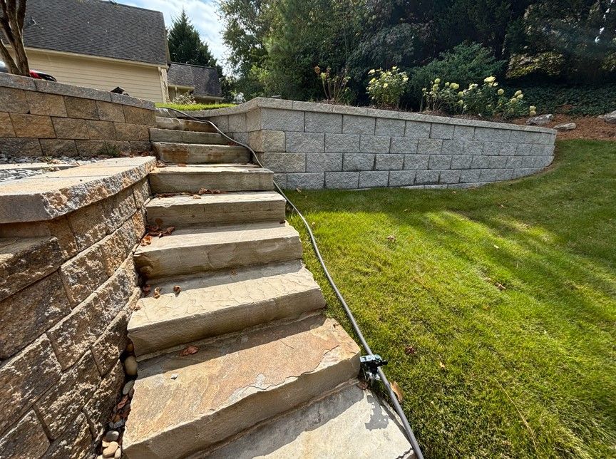 A set of stairs leading up to a brick wall in a backyard.