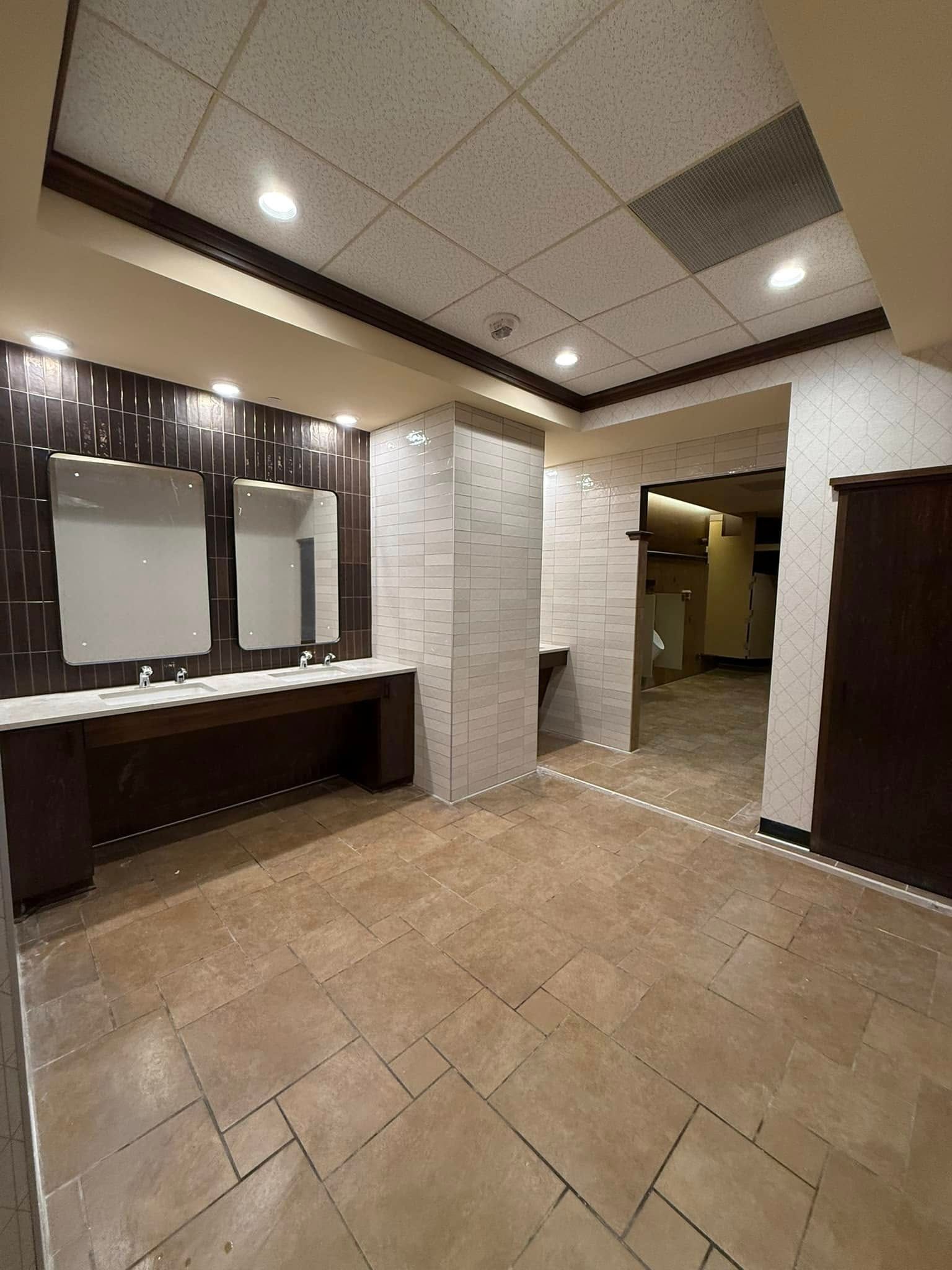 A bathroom with two sinks and two mirrors on the wall.