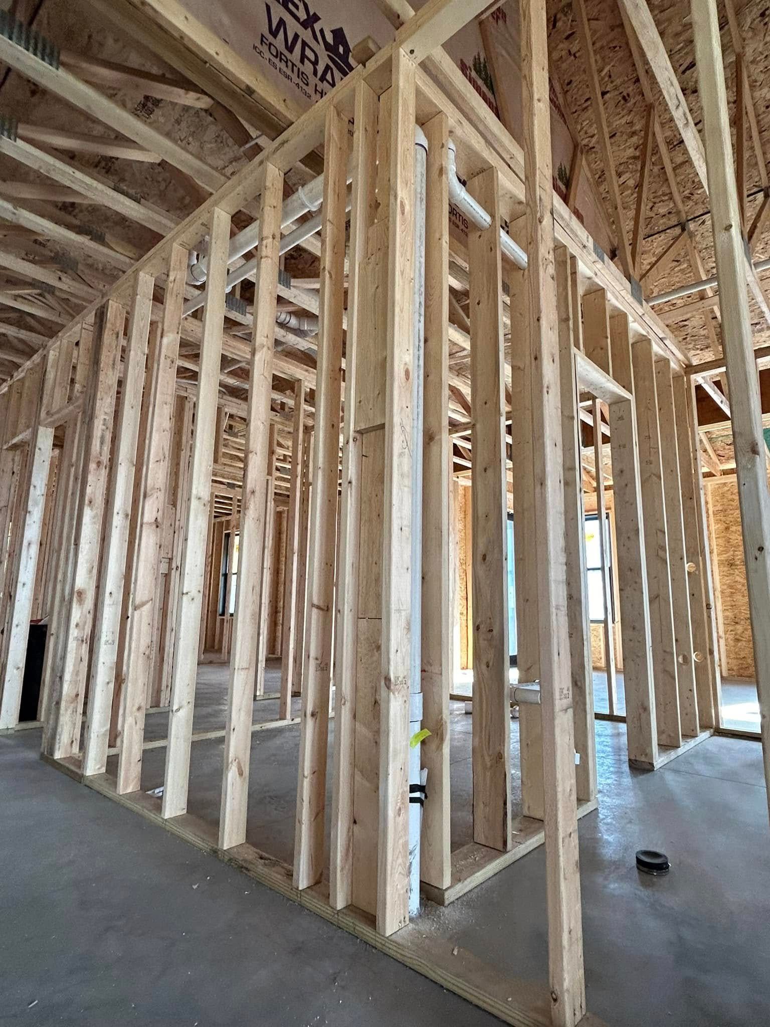 The inside of a house under construction with a lot of wooden beams.