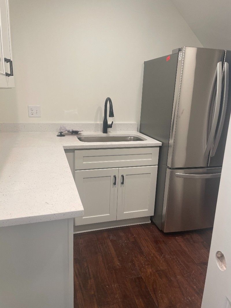 A kitchen with a sink , refrigerator , and stainless steel appliances.