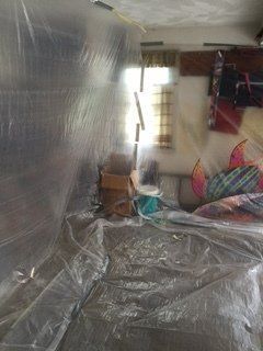 Room covered in plastic sheeting, possibly for construction or renovation.