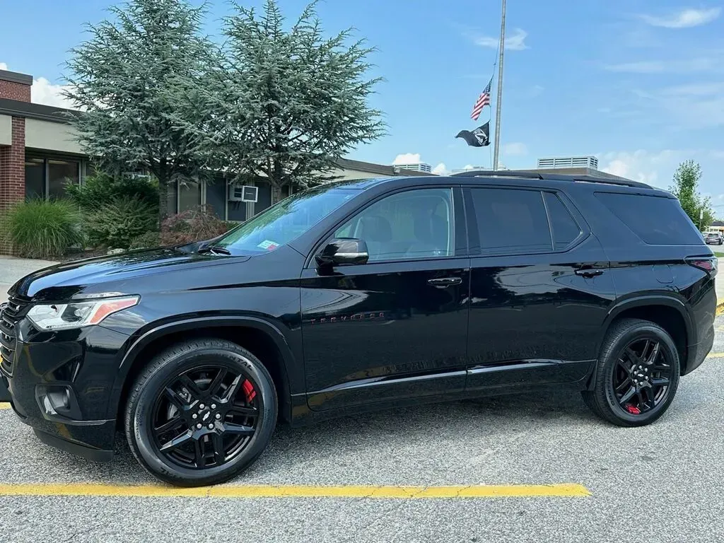 A black SUV is parked in a parking lot in front of a building.