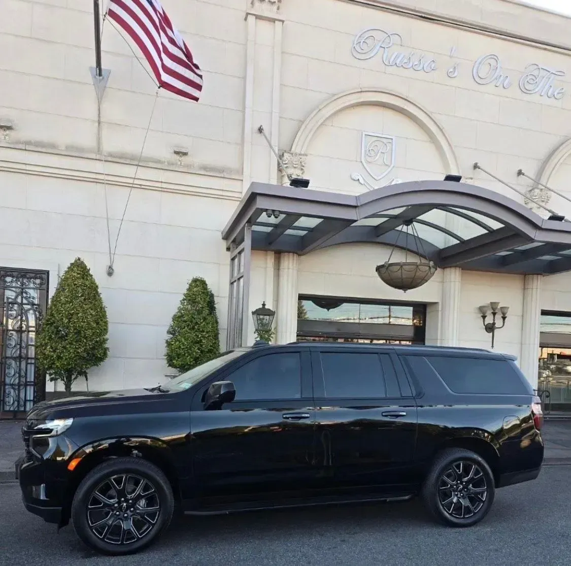 A black SUV is parked in a parking lot.