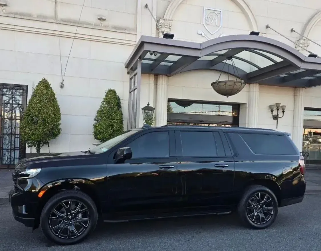 A black SUV is parked in front of a building.