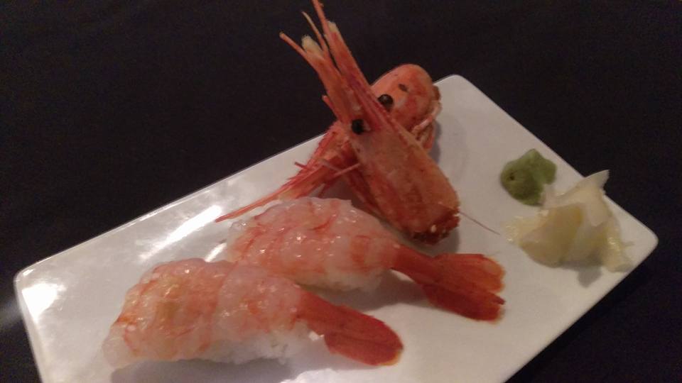 A white plate topped with shrimp and wasabi