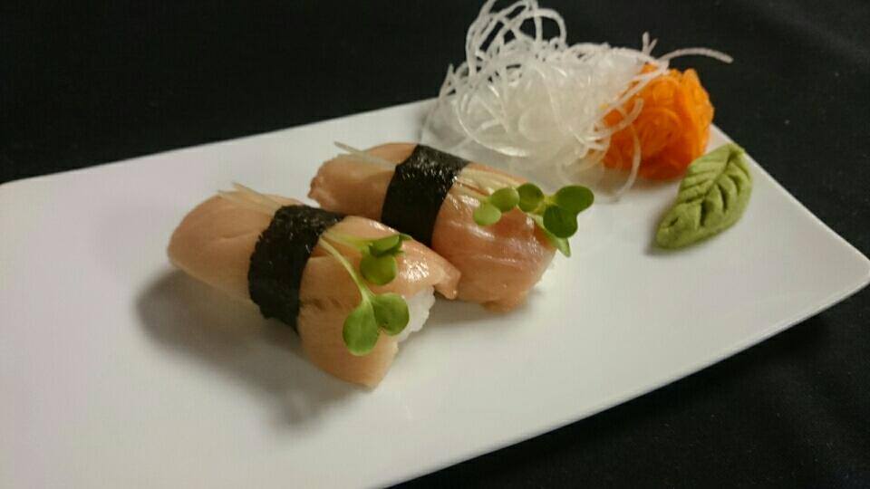 A white plate topped with sushi and vegetables on a table.
