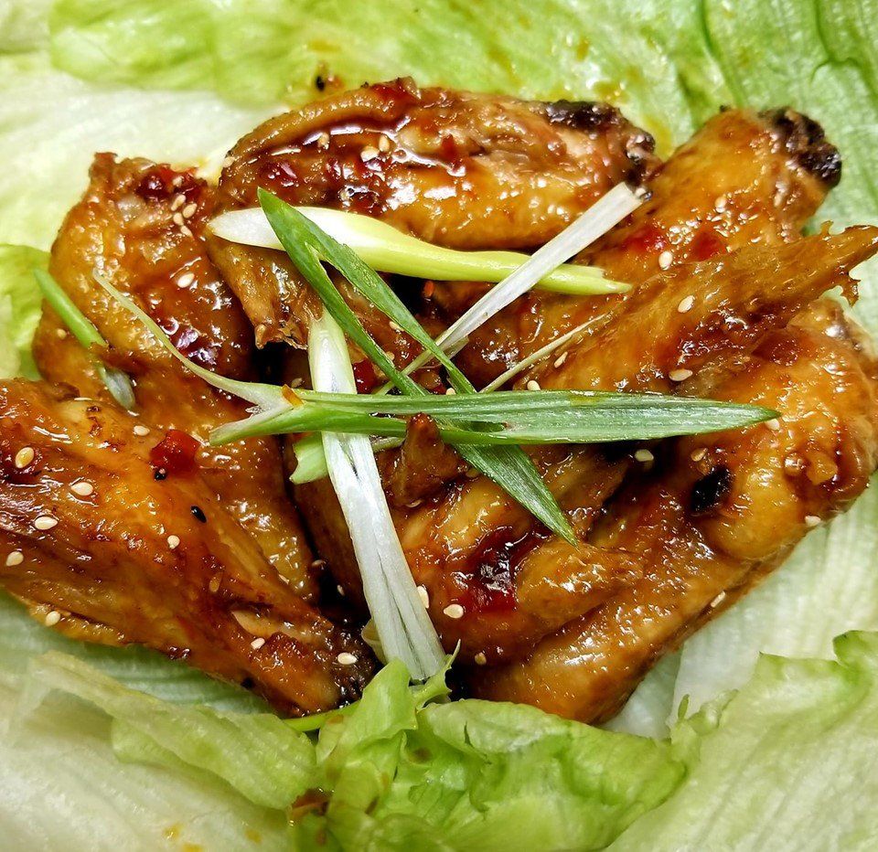 A close up of chicken wings on a lettuce leaf