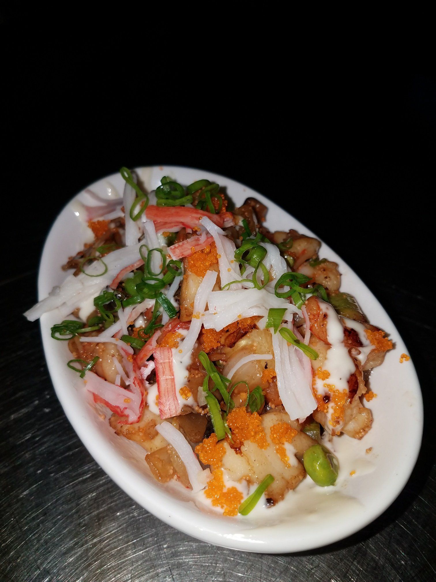 A white plate topped with a variety of vegetables and crab sticks.