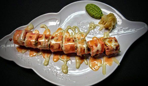 A close up of a plate of sushi on a shell shaped plate.