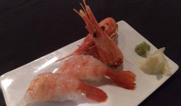 A white plate topped with shrimp and wasabi