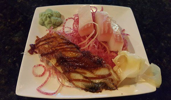 A white plate topped with a piece of meat and vegetables.