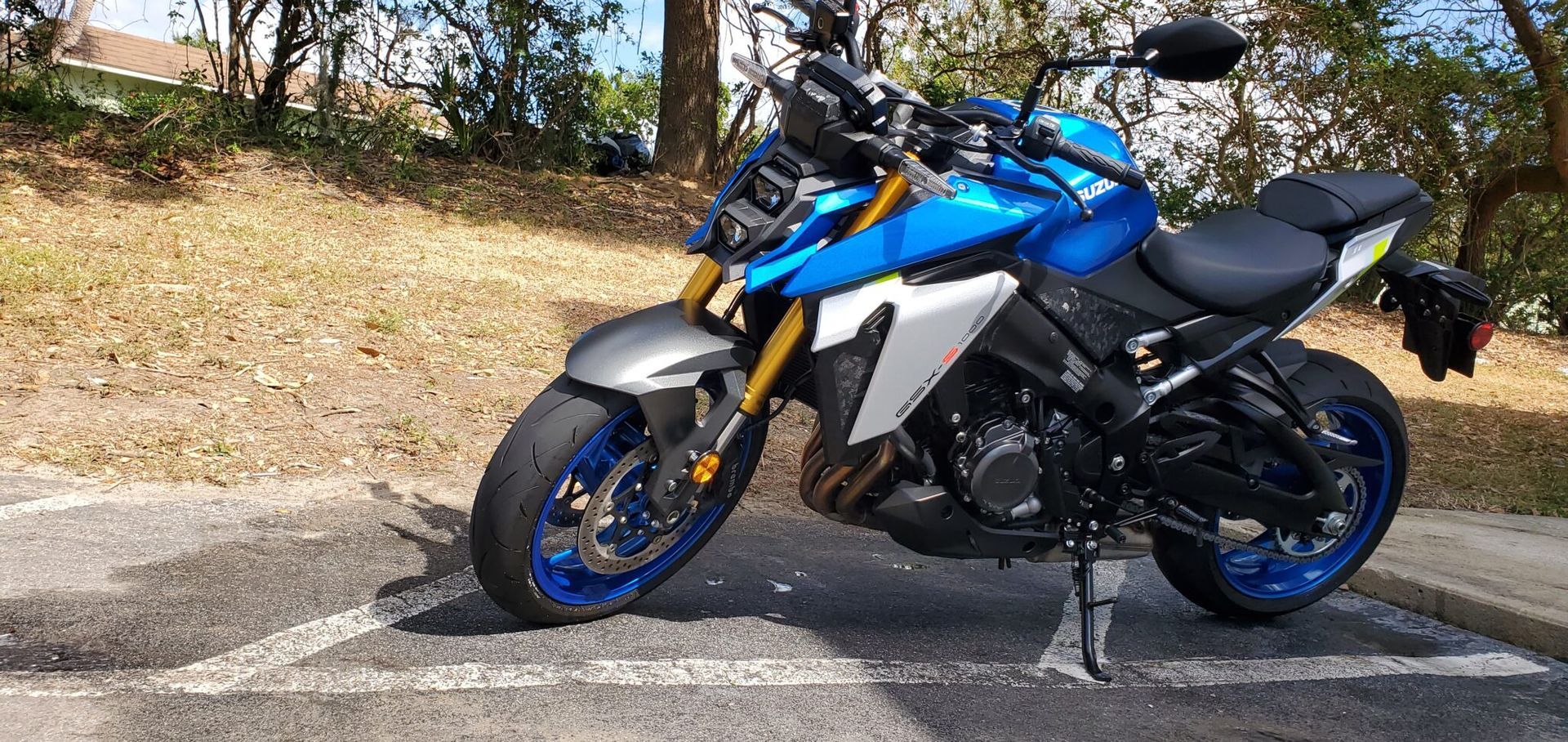 Blue and silver Suzuki motorcycle parked outdoors.