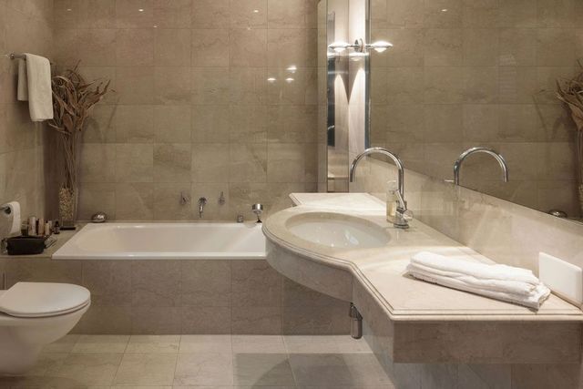 A bathroom with a sink , toilet , bathtub and mirror.