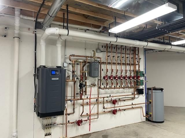 A room with a lot of pipes hanging on the wall.