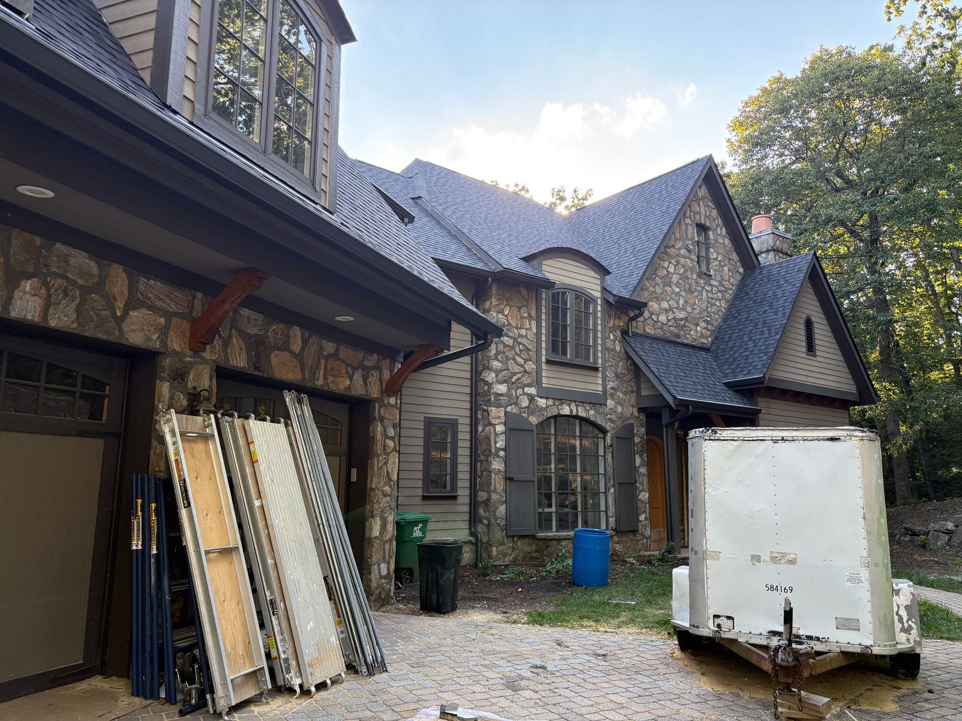 Stone house exterior with a garage and construction equipment.