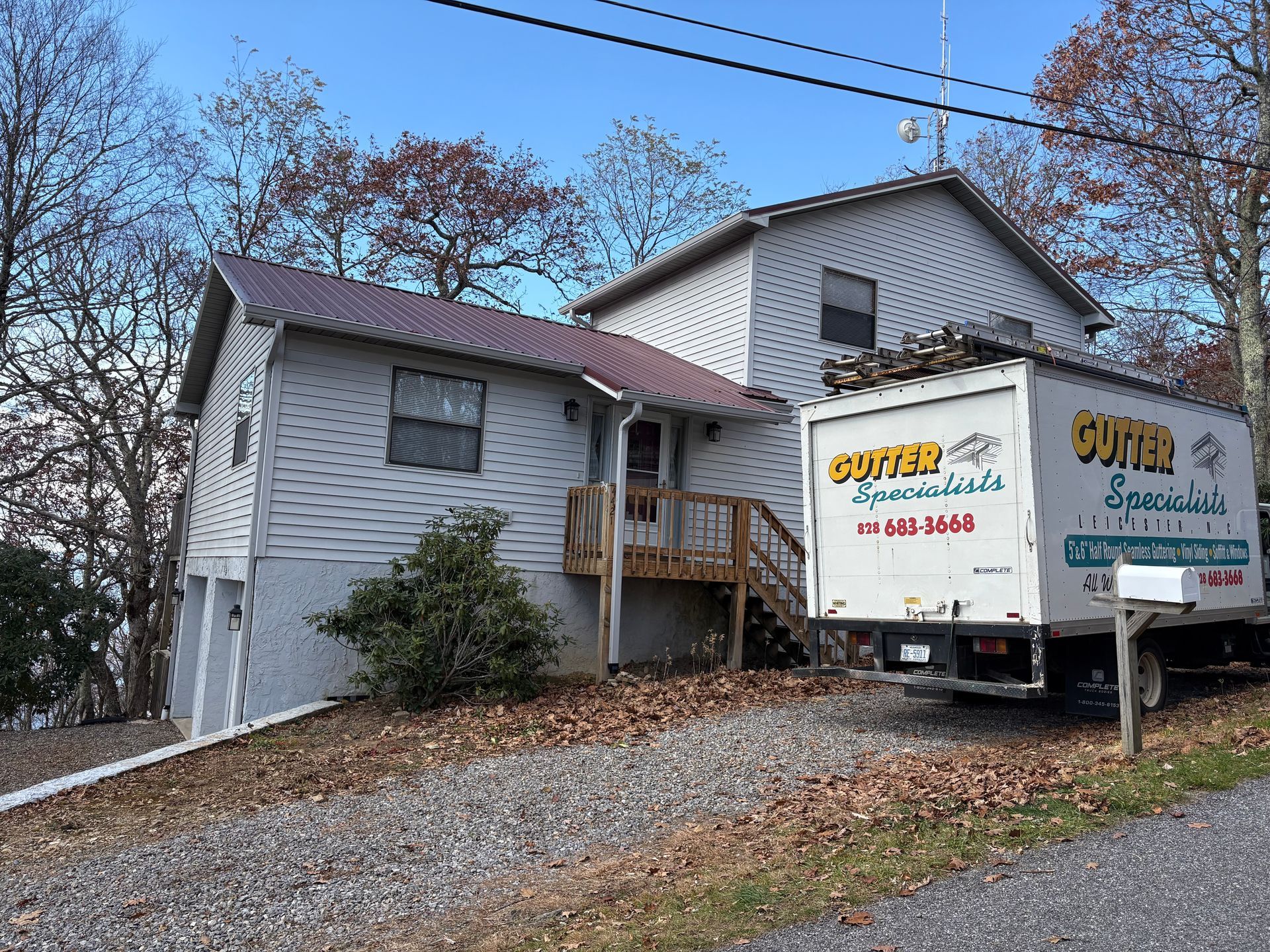 Two-story house with a delivery truck parked on the side. The truck reads 