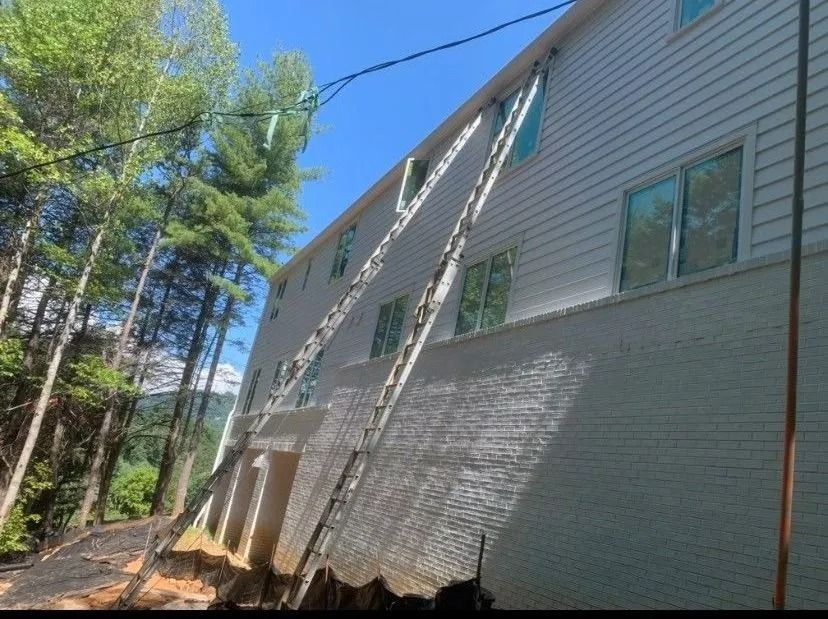 A multi-story building with support beams angled against the side. The foundation shows exposed brick.