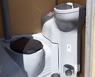 A toilet and sink are in a portable toilet.
