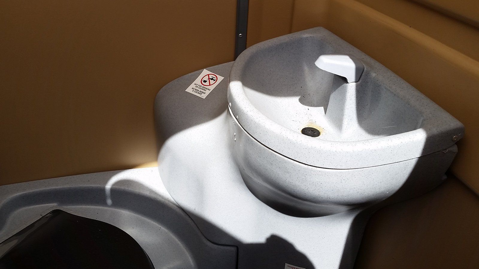 A close up of a toilet and sink in a bathroom.