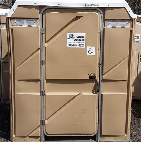 A portable toilet with a handicap sticker on the door