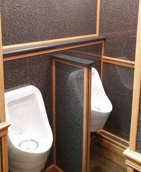 A bathroom with two urinals and a toilet