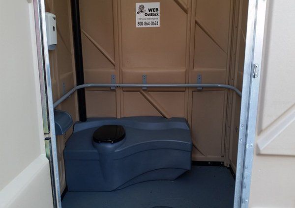 A portable toilet with a sign that says web on it