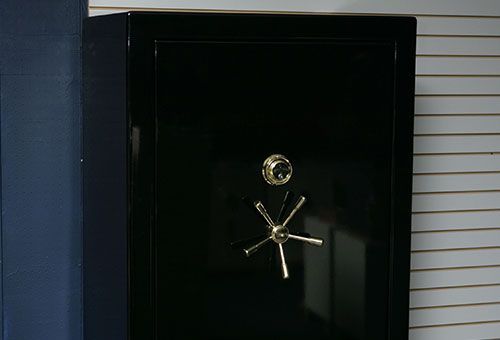 Black safe with gold handle, on display.