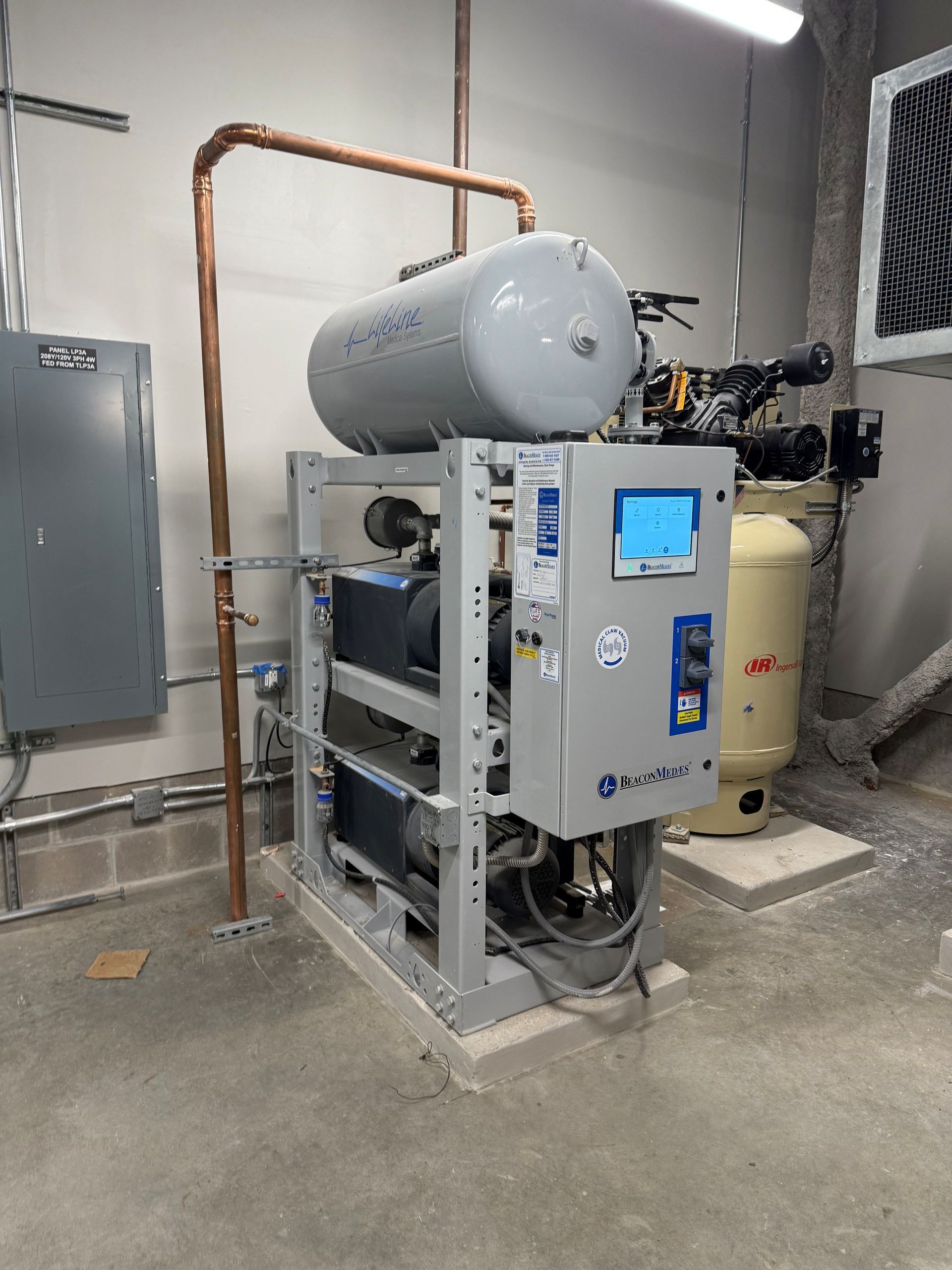 A commercial water heating system in a utility room with copper pipes.