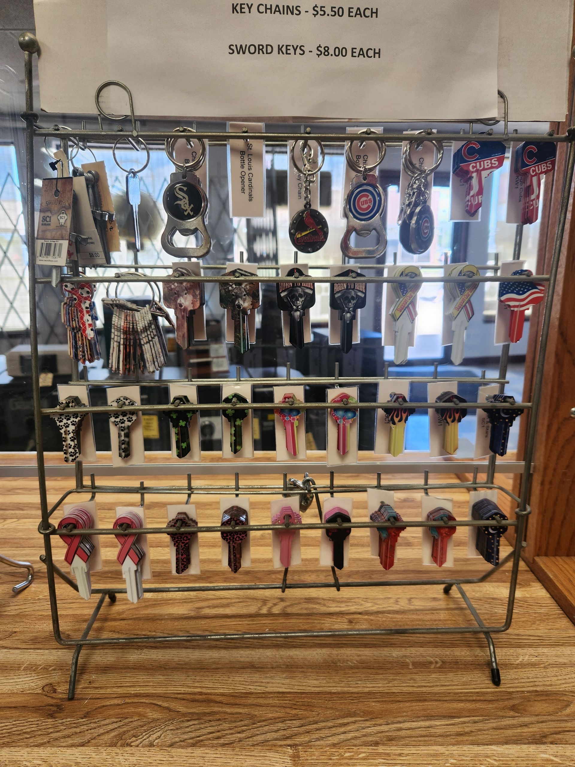 Keychains on a display rack; price signs above. Wooden table in shop setting.