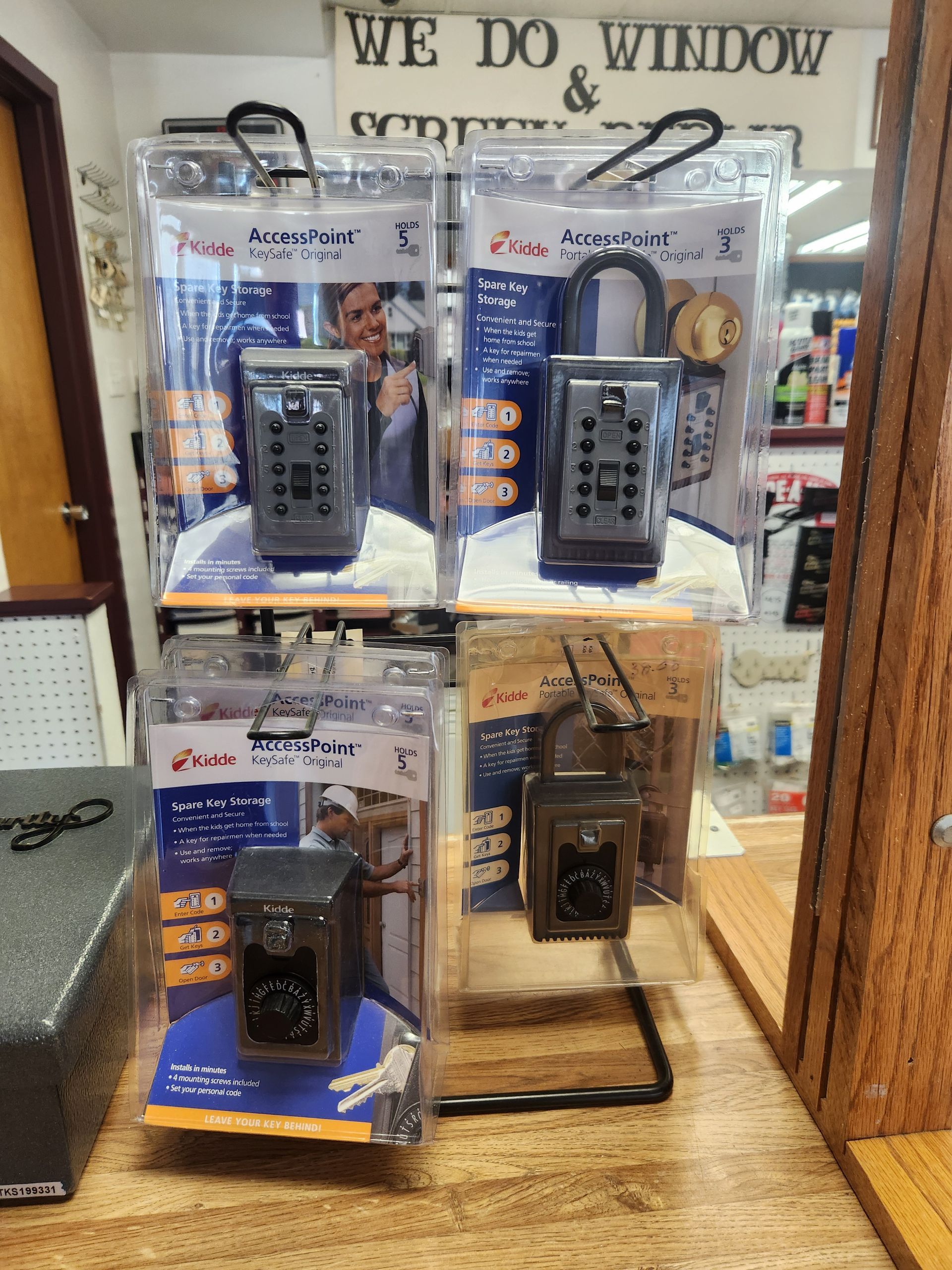 Display of key safes in packaging, on a wire rack, at a store.